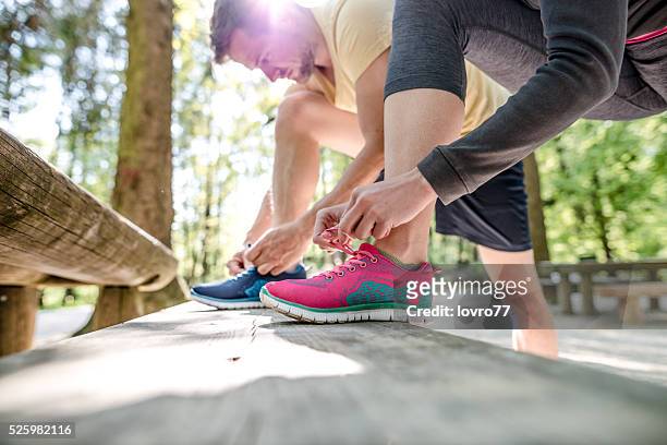 couple tying shoes - tied up stock pictures, royalty-free photos & images