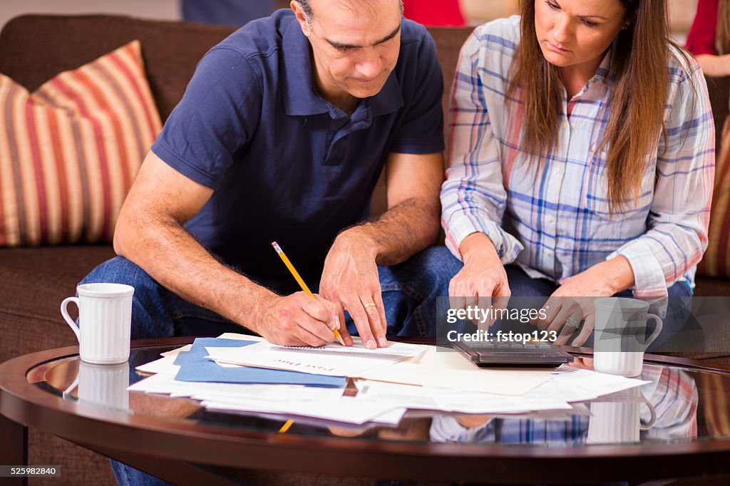 Latin descent couple paying monthly bills at home.