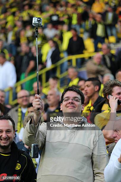 Fan of Borussia Dortmuns holds up a GoPro camera