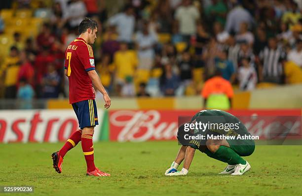 David Villa of Spain goes to a dejected Mickael Roche of Tahiti after the end of the game that Spain won 10-0