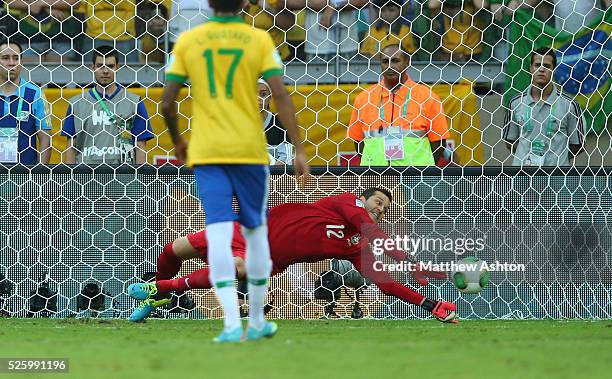 Julio Cesar of Brazil saves a first half penalty taken by Diego Forlan of Uruguay