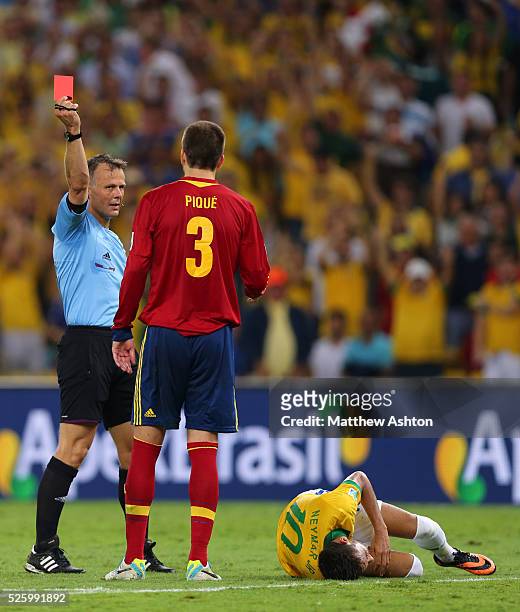 Referee Djamel Haimoudi from Algeria shows a red card to Gerard Pique of Spain after his foul on Neymar of Brazil