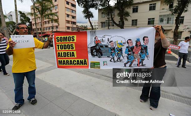 Protestors carry a banner outside the Estadio Jornalista Mario Filho / Maracana Stadium in Rio de Janeiro, Brazil to protest about the Police Raid on...