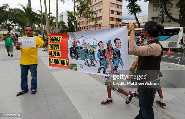 Protestors carry a banner outside the Estadio Jornalista Mario Filho / Maracana Stadium in Rio de Janeiro, Brazil to protest about the Police Raid on...