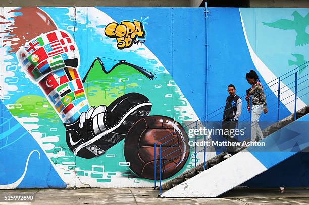 Locals walk down steps from the Maracana Metro, serving the Estadio Jornalista Mario Filho / Maracana Stadium in Rio de Janeiro, Brazil past a...