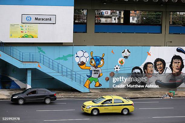 Traffic passes a football mural painting on the wall of the Maracana Metro, serving the Estadio Jornalista Mario Filho / Maracana Stadium in Rio de...