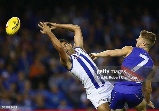 Daniel Wells of the Kangaroos is challenged for the ball by Lachie Hunter of the Bulldogs during the round six AFL match between the North Melbourne...