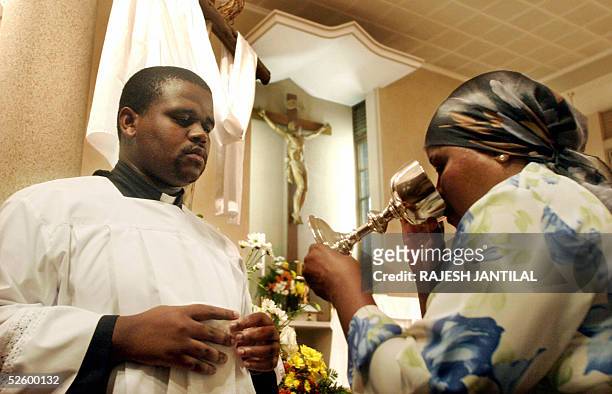 An altar server is part, 7 April 2005, of a communion during a mass prayer service in honour of Pope John Paul II at Our Lady of Fatima Catholic...