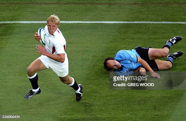 England's flanker Lewis Moody evades Uruguay's centre and captain Diego Aguirre on his way to scoring a try during the Rugby World Cup Pool C game...