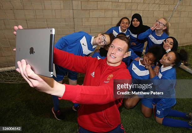 Phil Jones of Manchester United meets with children from a local school as part of the MU Foundation Players Day at Aon Training Complex on April 28,...