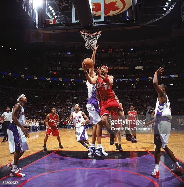 Drew Gooden of the Cleveland Cavaliers goes to the basket past Loren Woods of the Toronto Raptors during a game at Air Canada Centre on March 20,...