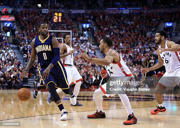 Miles of the Indiana Pacers dribbles the ball as Norman Powell of the Toronto Raptors defends in the first half of Game Five of the Eastern...