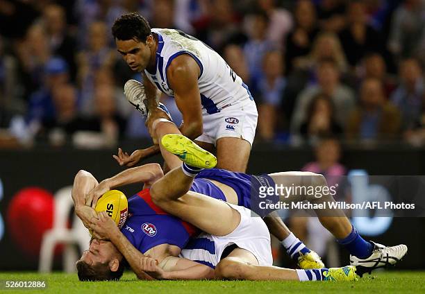 Fletcher Roberts of the Bulldogs is tackled Sam Wright and Daniel Wells of the Kangaroos by during the 2016 AFL Round 06 match between the North...
