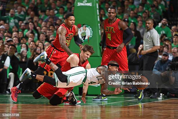 Isaiah Thomas of the Boston Celtics dives and passes the ball while guarded by Kyle Korver of the Atlanta Hawks in Game Six of the Eastern Conference...