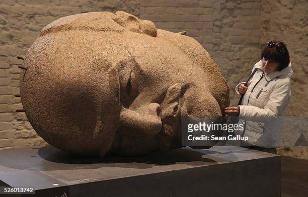 Visitor touches a bust of Russian revolutionary Vladimir Lenin at the exhibition: "Uncovered. Berlin and its Monuments" at the Spandau citadel on...