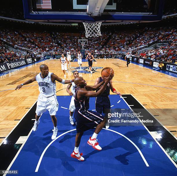 Jacque Vaughn of the New Jersey Nets takes the ball to the basket past Steve Francis of the Orlando Magic during the game at TD Waterhouse Centre on...
