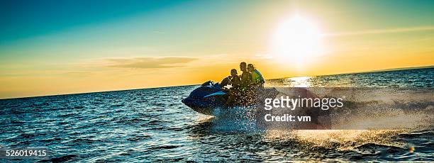 familia montar moto de agua en la puesta de sol - jet boat fotografías e imágenes de stock