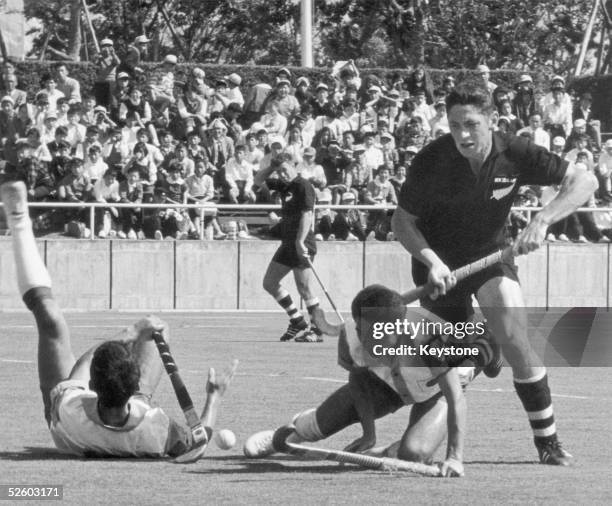 Field hockey game between Japan and New Zealand at Komazawa Olympic Park, 15th October 1964. New Zealand's Ernest Barnes rushes to the ball in the...