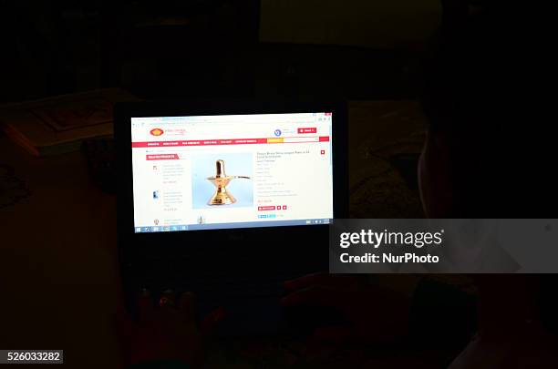 An indian hindu devotee searches worship materials for Maha Shivratri festival worshipping on online website indianworship.com, on the eve of Maha...