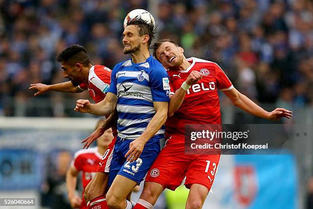 Kerem Demirbay of Duesseldorf , Adam Bodzek of Duesseldorf and James Holland of Duisburg go up for a header during the 2. Bundesliga match between...