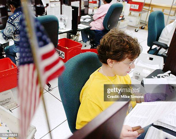 Jessica Orr sorts tax returns with an American Flag in the foreground at the Cincinnati Internal Revenue Service Center April 8, 2005 in Covington,...