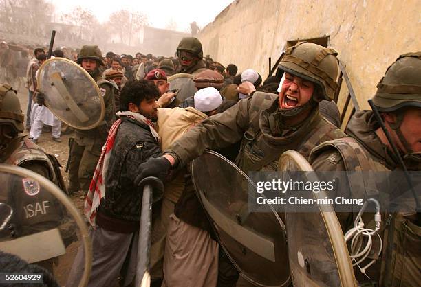 German ISAF peacekeeper controls a crowd at a soccer game on February 15, 2002 in Kabul, Afghanistan. Only a limited number of tickets were given...