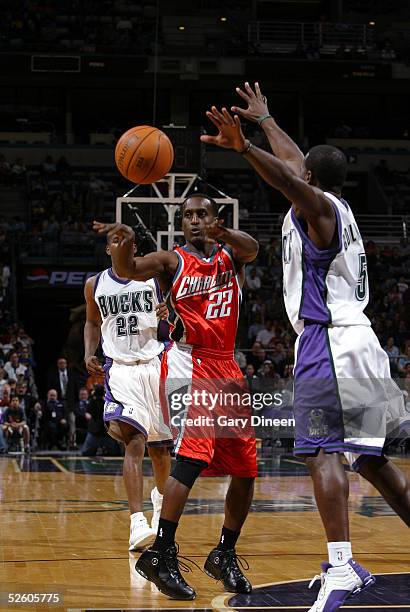 Brevin Knight of the Charlotte Bobcats passes the ball against Anthony Goldwire of the Milwaukee Bucks as Michael Redd of the Milwaukee Bucks looks...