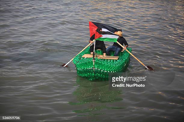 Young Palestinians on their boat made from remnants of empty plastic bottles inside the port of Gaza City