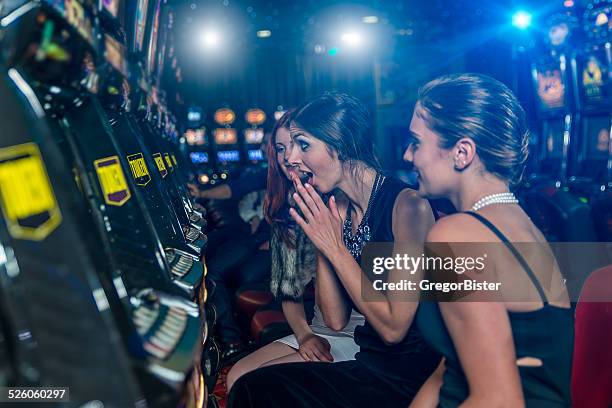 woman in a casino winning at slot machine - casino elegance stock pictures, royalty-free photos & images