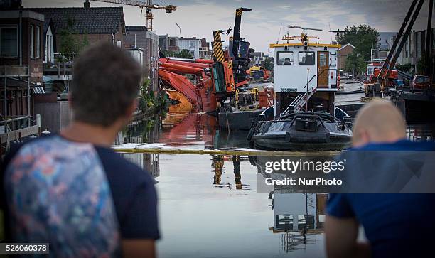 Aug. 6, 2015 - Two large cranes carrying a part of a bridge weighing 190 tons slid of a pontoon and crashed into several houses along the canal. The...