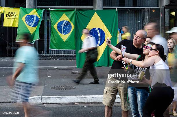 Protesters take a selfie in front of brazilian flags being sold during demonstration in avenida Paulista, downtown S��o Paulo, Brazil, requesting the...