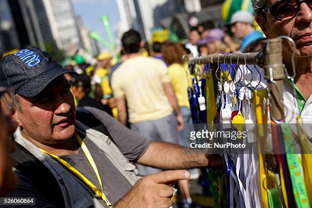 Man sells whistles on Paulista Avenue where thousands of people protest against the government of the president Dilma Rousseff in Sao Paulo, Brazil...