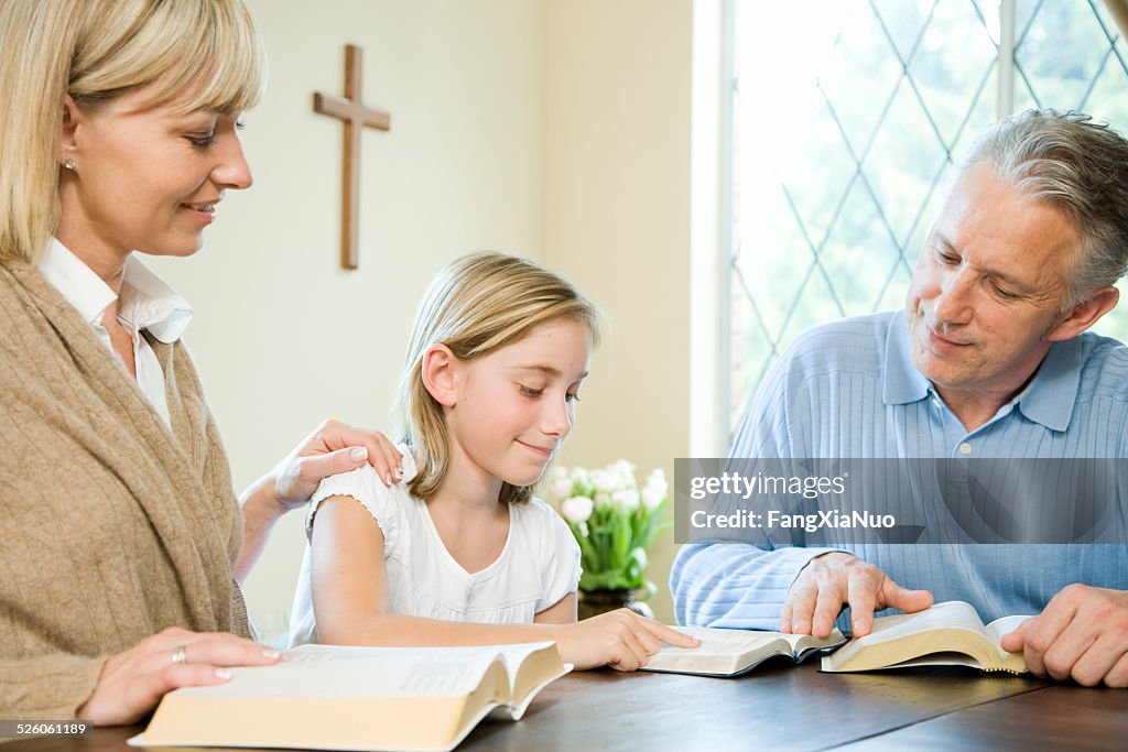 Family Reading Bibles at Table