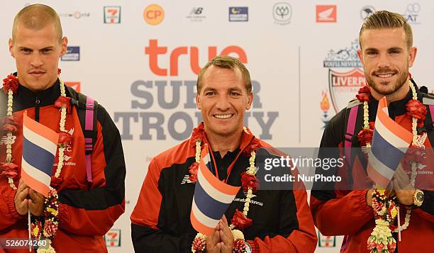 Martin Skrtel, Brendan Rodgers and Jordan Henderson of Liverpool pose with Thailand flag as they arrive at Suvarnabhumi airport in Samut Prakan,...