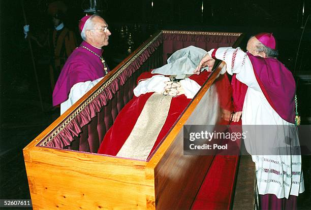 Archbishop Stanislaw Dsiwisz places a white veil over the face of late Pope John Paul II as Archbishop Piero Marini looks on, prior to closing the...