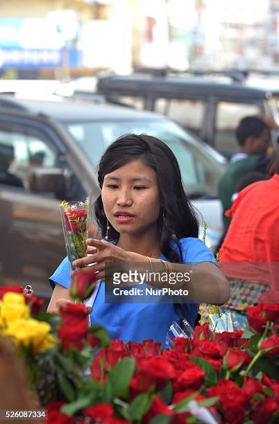 Naga girl browses red rose in a street market in Dimapur ahead of Valentines Day in the India eastern state of Nagaland on Saturday, February 13,...