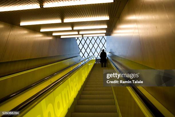 Man rides up the escalator in Seattle Public Library's central branch, designed by Dutch architect Rem Koolhaas of OMA . Opened in 2004, Seattle...