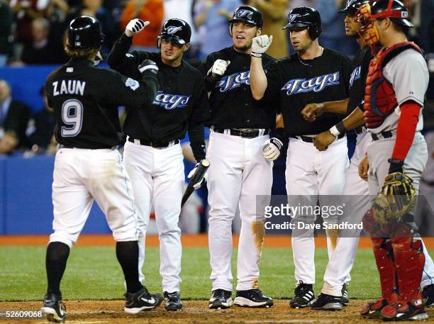Gregg Zaun of the Toronto Blue Jays celebrates his grand-slam home run against the Boston Red Sox with his teammates John McDonald,Shea Hillenbrand,...