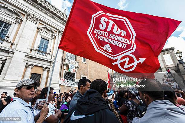 'Housing rights' activists wave flags as they take part in a demonstration to protest against forced housing evictions in Rome on September 23, 2015....