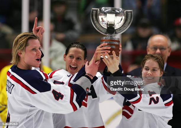 Angela Ruggiero, Cammi Granato and Jenny Potter of team USA celebrate with the winner's trophy after defeating team Canada in a shoot-out to win the...