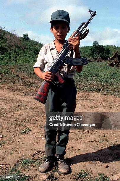 Young contra fighter stands at attention in a base camp located inside Honduras. These child volunteer fighters would arrive at base camps...