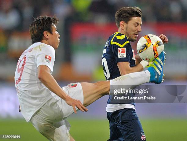 Ja-Cheol Koo of FC Augsburg challenges Milos Jojic of 1. FC Koeln during the Bundesliga match between FC Augsburg and 1. FC Koeln at WWK Arena on...