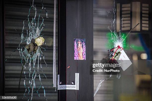 Flowers are left inside bullet hole through the glass of a Japanese restaurant next to &quot;La Belle Equipe&quot; restaurant in the 11th district of...