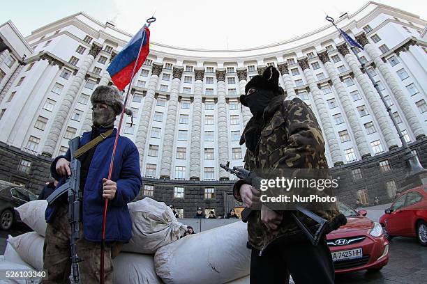 Ukrainian activists dressed like armed pro-Russian terorists perform during their rally in front of the Government building in Kiev, Ukraine, 15...