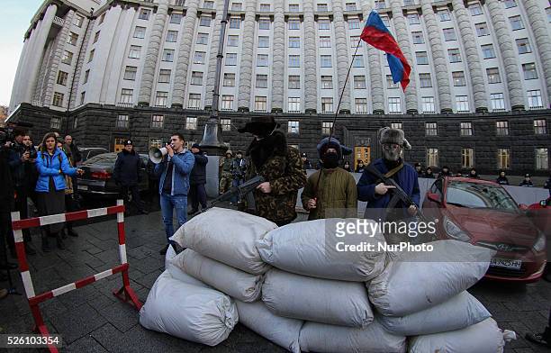 Ukrainian activists dressed like armed pro-Russian terorists perform during their rally in front of the Government building in Kiev, Ukraine, 15...