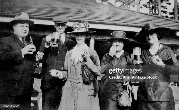 Group eats hot dogs and drinks root beer, ca. 1920