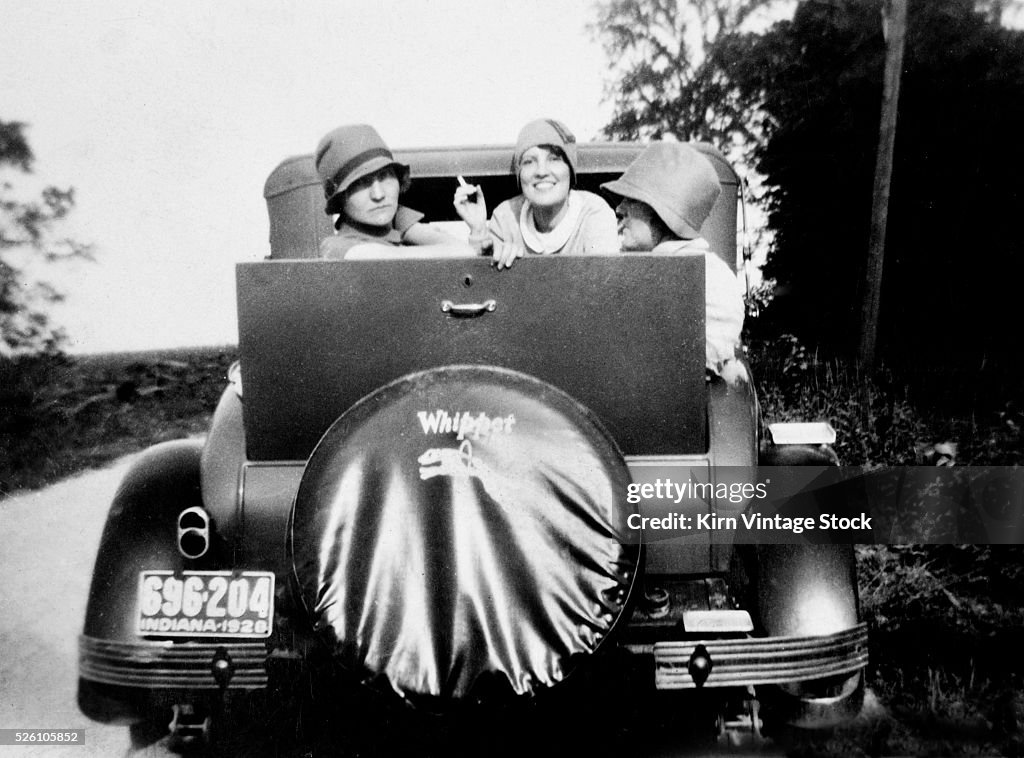 Three flappers pose in the jump seat of a Whippet car, ca. 1928