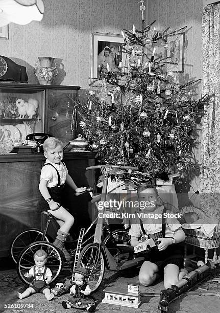 Two brothers are shown with their toys under the Christmas tree in Germany, ca. 1949