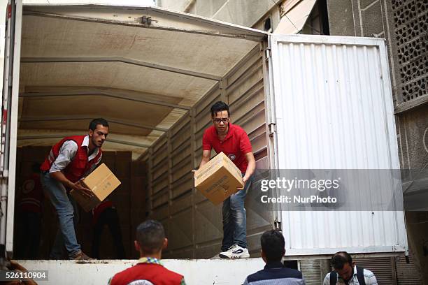 Members of Syrian Arab Red Crescent - Douma bransh lower the relief materials from their trucks, The trucks loaded with vaccines and medical...