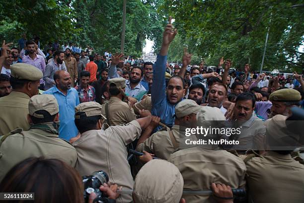 Indian police stop Kashmiri government employees as they shout slogans during a protest against the government on August 10, 2015 in Srinagar, the...